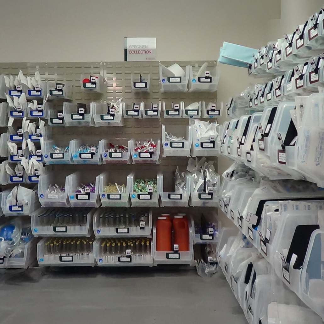 Medical supplies are organized in clear bins on shelves using a Kanban system.