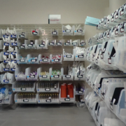Medical supplies are organized in clear bins on shelves using a Kanban system.